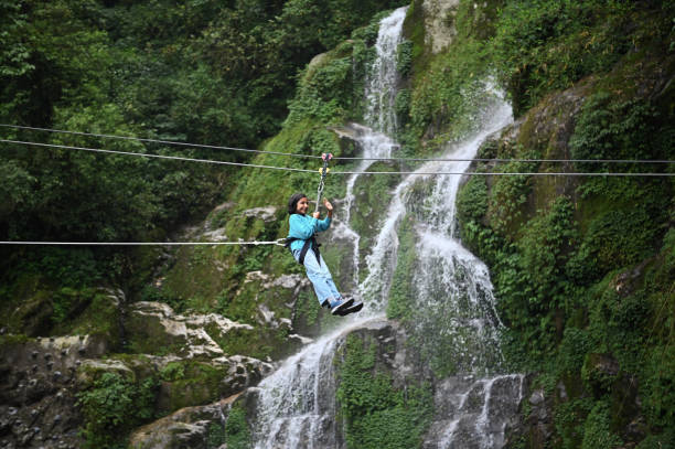 A girl zip-lining near a waterfall in Gangtok, Sikkim