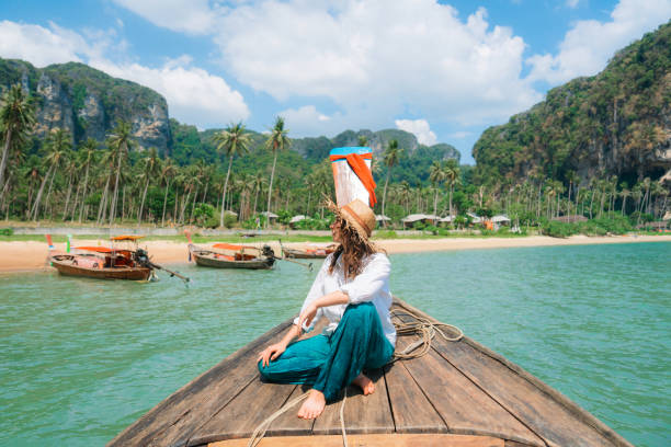 Cheerful woman traveling with Thai taxi boat in Ao Nang, Krabi