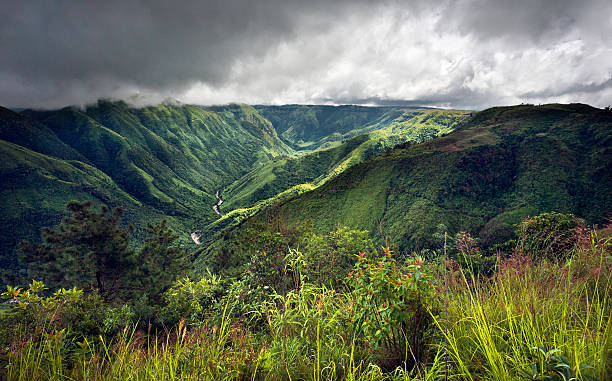 A panoramic view of the Khasi Hills situated in the state of Meghalaya, north east India. These hills are situated in the district of Cherrapunjee, once the wettest place on earth. This photograph show a very heavy and overcast sky. A storm is brewing and a shaft of light outlines the deep valley gorge.