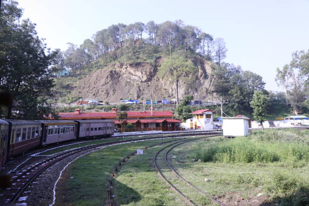 A train running in the hills taking a turn on curvy track
