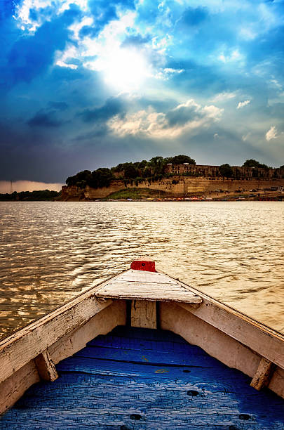 big wooden boats in water with cloudy sky and sunbeams at allahabad indian asia